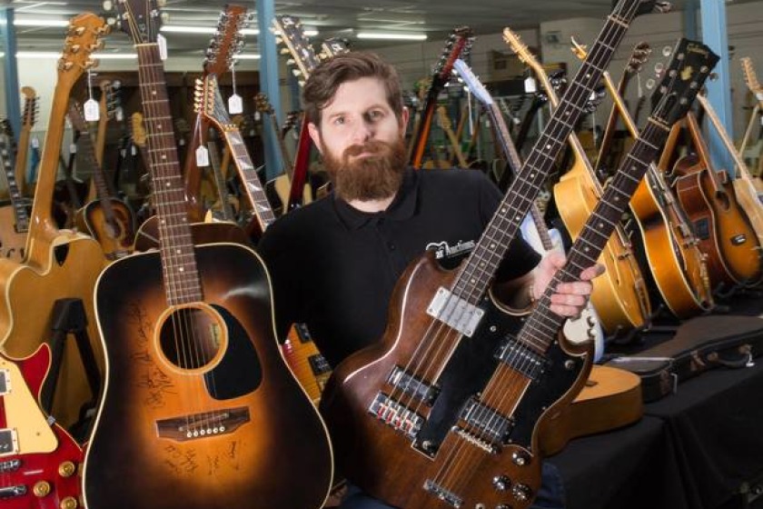 Luke Hobbs, of auctioneers Gardiner Houlgate, with the Gibson J45 (left) and Gibson doubleneck guitars (Clare Hobbs Photography/PA)